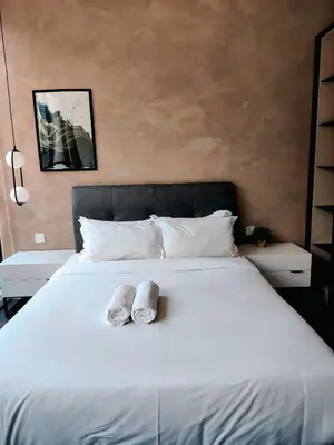 a bed with two towels sitting on top of it at Scarletz Suites KLCC by IH in Kuala Lumpur