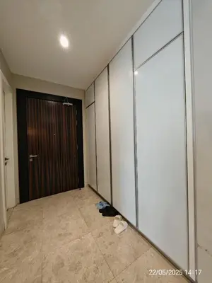 a hallway with a door and a pair of shoes at Icon Residence in Kuala Lumpur