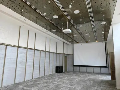 a large room with a white screen and a podium at TRX Agile Bukit Bintang Deluxe 8 pax Family Suites in Kuala Lumpur