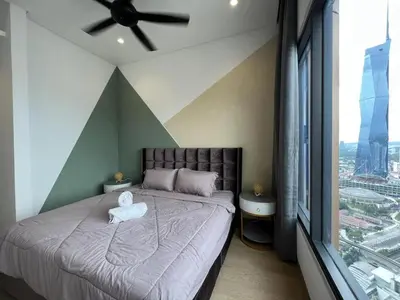 a bedroom with a large bed with a ceiling fan at Lucentia Residences BBCC LaLaport in Kuala Lumpur