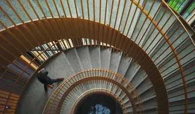 a man walking down a spiral staircase in a building at Lucentia Residences BBCC LaLaport in Kuala Lumpur