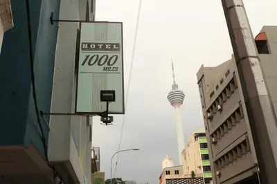 a sign for a hotel with the korean tv tower in the background at Hotel 1000 Miles in Kuala Lumpur