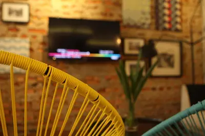 a yellow rattan chair in a room with a fireplace at Hotel 1000 Miles in Kuala Lumpur