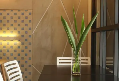 a glass vase with a plant on a table at Hotel 1000 Miles in Kuala Lumpur