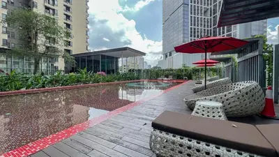 a pool with a table and an umbrella and chairs at Kuala Lumpur Digital Work Base in Kuala Lumpur