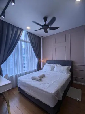 a bedroom with a bed with a ceiling fan at Dawn Getaways in Kuala Lumpur