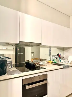 a kitchen with white cabinets and a stove top oven at Dawn Getaways in Kuala Lumpur