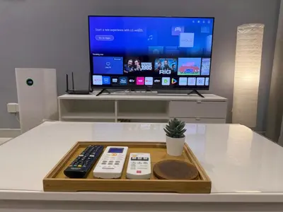 a tray with remote controls and a tv on a table at Continew Residence Studio Apartment in Kuala Lumpur