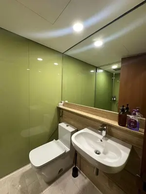 a bathroom with a toilet and a sink and a mirror at Sleep in the Sky KLCC View in Kuala Lumpur