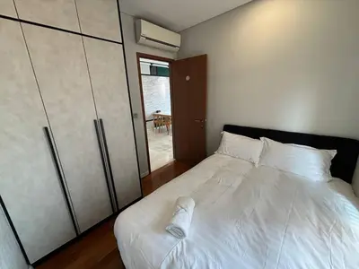 a bedroom with a white bed and a closet at Sky Suites KLCC by Easy Nap in Kuala Lumpur