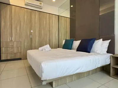 a bedroom with a large bed with wooden cabinets at Balcony Cityscape IIII The Robertson Residence 42f in Kuala Lumpur
