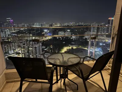 a table and chairs on a balcony with a view of a city at Balcony Cityscape IIII The Robertson Residence 42f in Kuala Lumpur