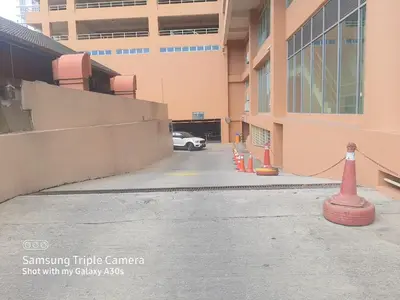 a car parked in a parking lot next to a building at Male Room at Plaza Rah, KL City Centre in Kuala Lumpur
