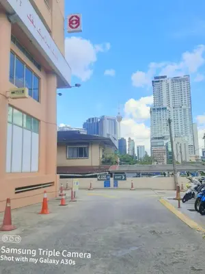a parking lot with orange cones in front of a building at Male Room at Plaza Rah, KL City Centre in Kuala Lumpur