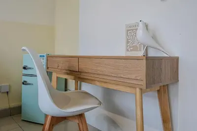 a desk with a chair and a book and a lamp at Stylish M Vertica 4 Bedroom Walk to MRT Velocity Mall in Kuala Lumpur