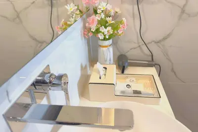 a table with a phone and a vase with flowers at #TRX KL #2BR #4Pax #2Gbps #Netflix #Hotel Feel in Kuala Lumpur