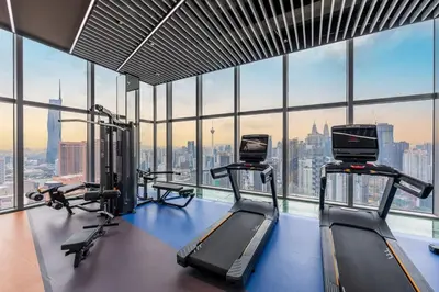 a gym with three tread machines in a large window at #TRX KL #2BR #4Pax #2Gbps #Netflix #Hotel Feel in Kuala Lumpur