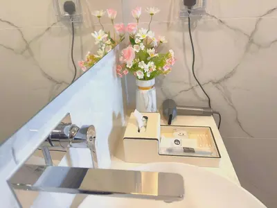 a counter with a vase of flowers in a bathroom at #TRX KL #2BR #4Pax #2Gbps #Netflix #Hotel Feel in Kuala Lumpur
