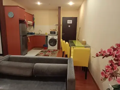 a living room with a couch and a table and a kitchen at Maytower Apartment Studio Kuala Lumpur in Kuala Lumpur