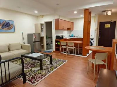 a living room with a couch and a table and a kitchen at Maytower Apartment Studio Kuala Lumpur in Kuala Lumpur
