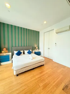 a bedroom with a large white bed with blue pillows at The Platinum KLCC By Homestay in Kuala Lumpur