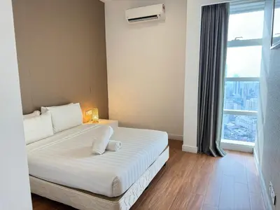 a white bed in a room with a large window at The Platinum KLCC By Homestay in Kuala Lumpur