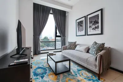 a living room with a couch and a tv at Opus by Soulasia in Kuala Lumpur