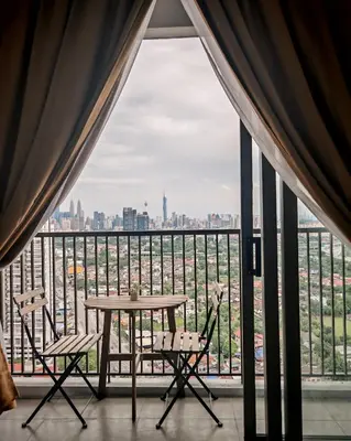 a table and chairs in front of a large window at View KLCC 3 Bedroom Homestay Kenwingston Platz in Kuala Lumpur