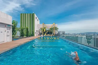 a woman swimming in a pool on top of a building at Maxhome Cozy at Riveria KL in Kuala Lumpur