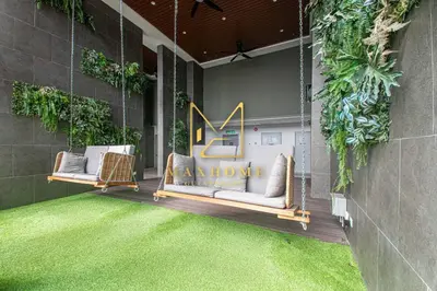 a porch with two couches on a patio with grass at Maxhome Cozy at Riveria KL in Kuala Lumpur