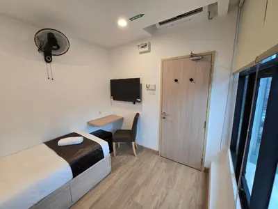 a bedroom with a bed and a desk and a tv at Seko Suites by Aurelius Chow Kit in Kuala Lumpur