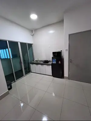 an empty room with a kitchen and a refrigerator at Modern High-Floor 2BR Retreat 9km to KL City Centre in Kuala Lumpur
