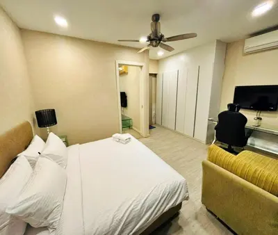 a bedroom with a bed and a couch and a ceiling fan at Bukit Bintang Fairlane suite by Rose in Kuala Lumpur