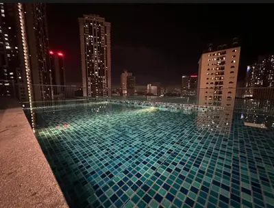 a swimming pool on the roof of a building at night at Cozy Chambers Studio KLCC Grand Opening Sale in Kuala Lumpur