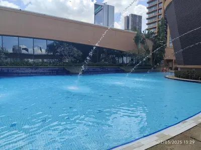 a large swimming pool with a water fountain at The Golden Suites at Berjaya Times Square Kuala Lumpur in Kuala Lumpur