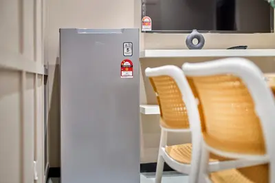 two chairs next to a refrigerator in a kitchen at Neu Suites Ampang near Gleneagles in Kuala Lumpur