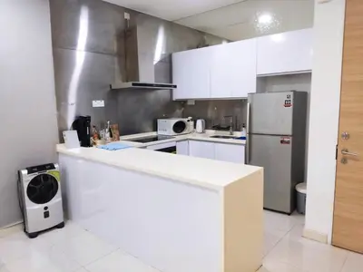 a kitchen with a white counter and a refrigerator at Camellia Serviced Suites in Kuala Lumpur