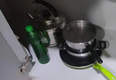 a green bottle and a pot on a stove at Camellia Serviced Suites in Kuala Lumpur