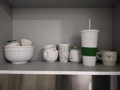 a shelf with a bunch of pots and cups on it at Camellia Serviced Suites in Kuala Lumpur