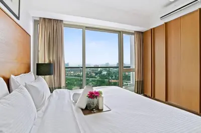 a bedroom with a large white bed with flowers on it at My Habitat KL in Kuala Lumpur