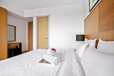 a bedroom with a white bed with towels on it at My Habitat KL in Kuala Lumpur