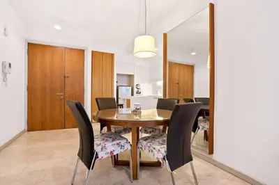 a dining room with a wooden table and black chairs at My Habitat KL in Kuala Lumpur