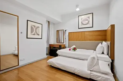 a bedroom with a large white bed and a mirror at My Habitat KL in Kuala Lumpur