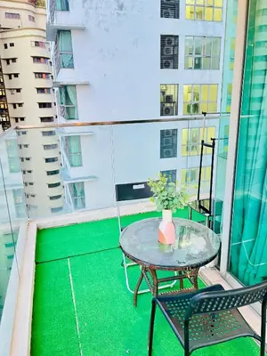 a table and chairs on a balcony with a green floor at Enjoy your stay Regalia view KLCC in Kuala Lumpur