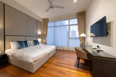 a hotel room with a bed and a desk at La Gente X Pavilion Embassy Serviced Suites in Kuala Lumpur