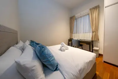 a bedroom with a bed with a teddy bear on it at La Gente X Pavilion Embassy Serviced Suites in Kuala Lumpur