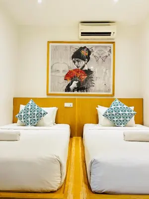 two beds in a room with a picture on the wall at Vivids Hotel Bukit Bintang in Kuala Lumpur