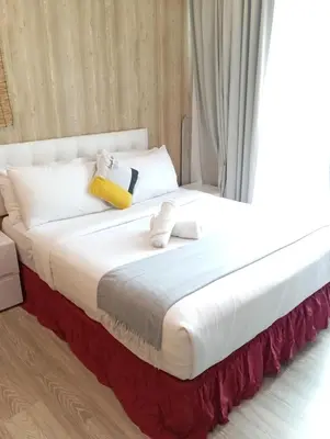 a bed with white sheets and pillows in a room at Bukit Ceylon Suites At RMAD KLCC in Kuala Lumpur