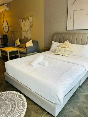 a large white bed in a room with a couch at Scarletz Suites KLCC by Dream in Kuala Lumpur