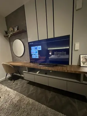a living room with a large screen tv on a table at Scarletz Suites KLCC by Dream in Kuala Lumpur